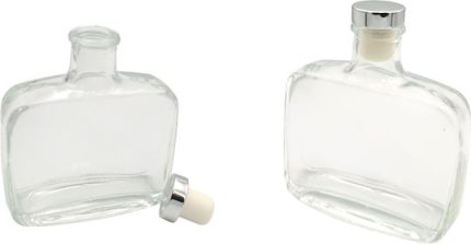 Two empty square glass bottles/decanters, one on its side with stopper nearby and the other upright with stopper in place.